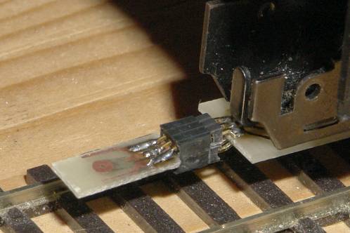 Het kleine printje met 2 rijen van 3 headers als stroomvoerende koppeling tussen lok en tender