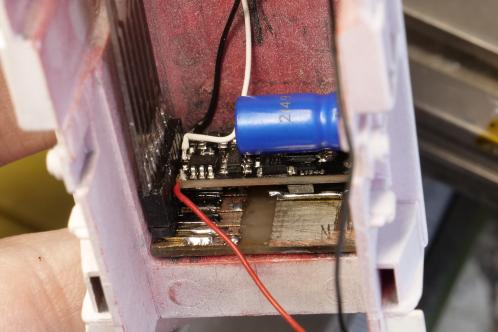 Een lichtroze kap van een modeltrein met meerdere electronicaprintjes precies ingebouwd in de betreffende kap