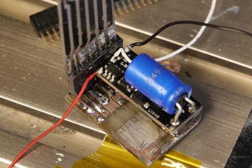 Meerdere electronicaprintjes en een blauwe goldcap, samen gemonteerd met pinheaders en andere onderdelen