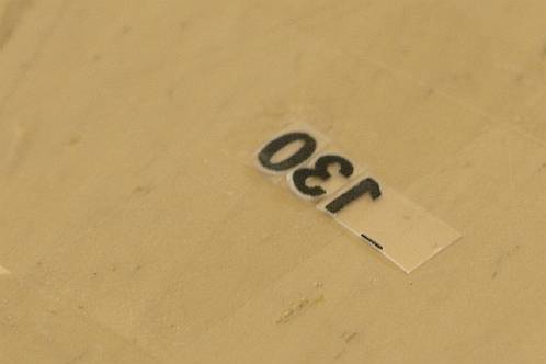 Het op plakband aanbrengen van het getal '130' voor het afgewreven werd op een knop van het fornuis
