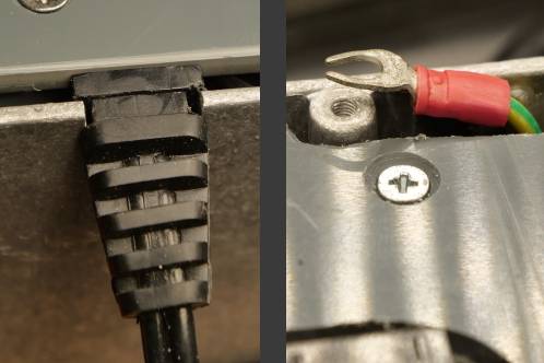 De aard-aansluiting met vork-kabelschoen die geplet wordt tussen deksel en bak van de behuizing en uitsparing voor de laagspanningskabel