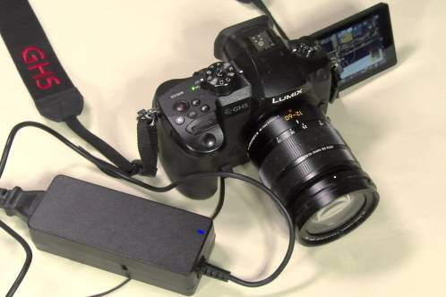 Een Panasonic GH5 fotocamera en een schakelende voeding als netvoeding in combinatie met de dummy-accu