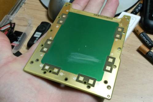 A large piece of gilded PCB, partially covered with green solder-resist