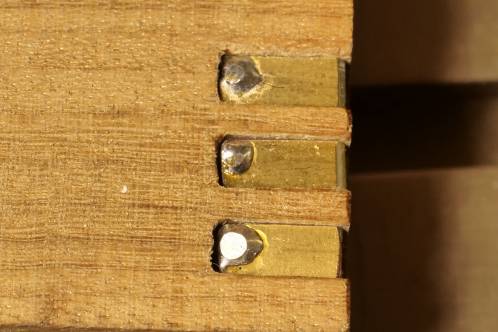 Three pieces of gilded PCB with solderjoint, mounted in a wooden block