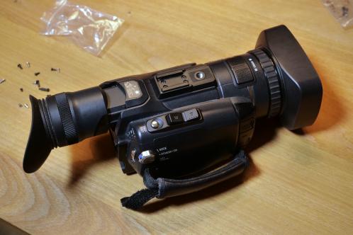 Een kleine zwarte, semi-professionele videocamera JVC-GY-HM100, weer volledig in elkaar na reparatie