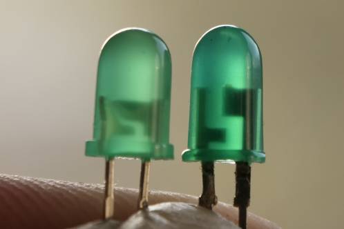Twee verschillende groene 5 millimeter LEDs naast elkaar, met duidelijk verschil in dikte van de kraag