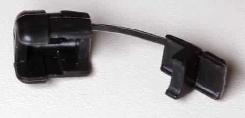 Een zwart-kunststof trekontlasting bestaande uit twee delen, verbonden met een klein plastic draadje