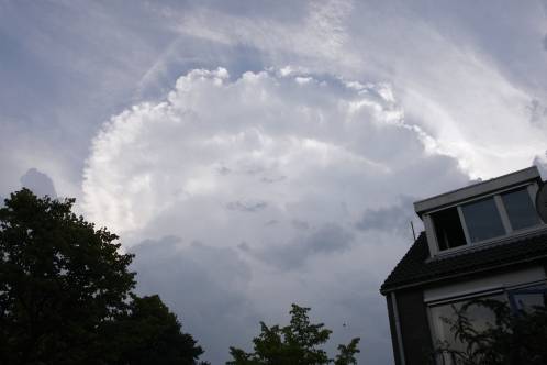 Een cumulonimbus met de duidelijke vorm van een atoomwolk hangt dreigend zichtbaar bij Purmerend in de buurt, lagere bewolking begint het zicht te ontnemen