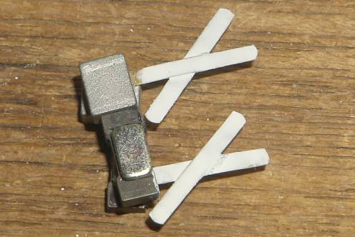 Andreaskruisen in de witte verf gezet door deze tussen twee magneetjes in te klemmen
