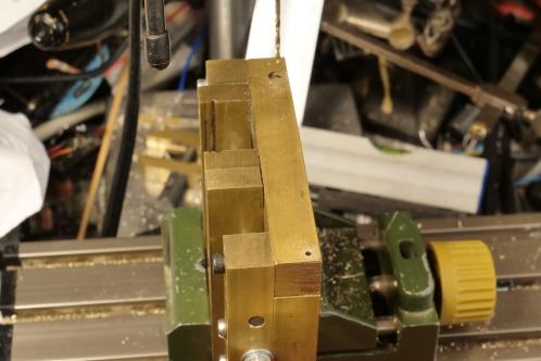 Een bijna voltooid messing bankschroefje in een machineklem voor het boren van de laatste gaten voor dwarsverbindingen