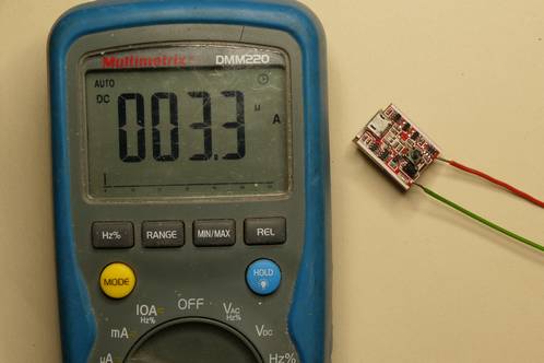 Een multimeter die een stroom van 3,3 micro-Ampère toont als ruststroom van een powerbank-controller