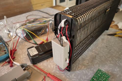 Diverse gekleurde draden, meetapparatuur en een geopend elektrisch apparaat, een vliegenlamp met hoogspanningsrooster en 2 UV TL-buizen