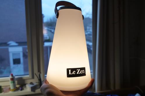 Een kegelvormige semi-transparante kunststof kap met lichtbron ingeschakelde toestand, een gerepareerde Le Zen Lux lamp