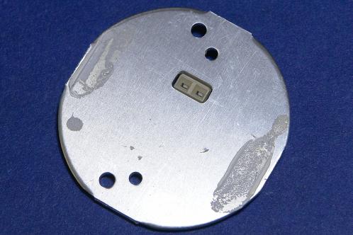 De cirkelvormige print van de achterkant gezien, met slechts twee streepjes (en dus ontoereikend) koelpasta op de aluminiumkleurige achterkant