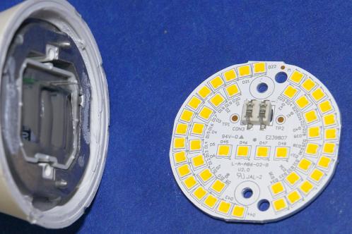 Een cirkelvormige aluminium print met 48 SMD LEDs, losgeschroefd van het aluminium koelblok dat links in beeld ligt