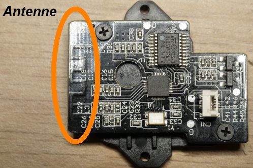 Een kleine zwarte printplaat met uitsluitend SMD-onderdelen in 0402 formaat, twee IC's, een antenne en connector voor verbinding met een andere print, de ontvangstmodule met A7105 IC van een Patona DMW-BGGH5RC batterygrip