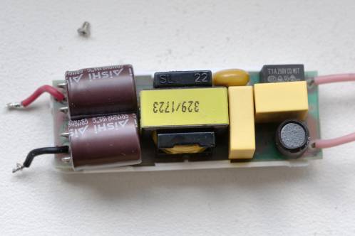 Een elektronicaprintje van een paar centimeter lang en breed met diverse onderdelen, de voeding van een Philips Master LEDtube