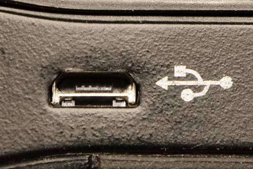 Een zwarte behuizing met micro-USB connector die scheef voor de uitsparing in de behuizing zit